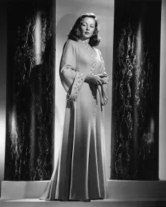 Tierney Prints: Gene Tierney models an apricot wool evening coat with gold