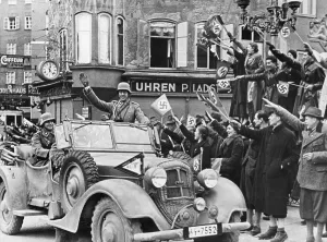 Salute Prints: German soldier waving to the Viennese crowd during Hitler's triumphant entry into Vienna