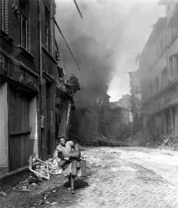 Lcgr1406 Prints: German woman runs from burning building carrying a suitcase and a few rugs