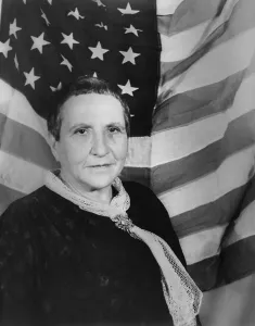 Backdrop Prints: Gertrude Stein, Avant guard expatriate poet with American flag as backdrop