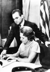 Segregationists Prints: Governor Lurlee and Governor George pose at the executive desk in the Alabama State Capitol