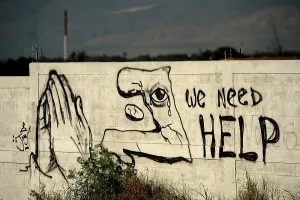 Suffering Prints: Graffiti asking for help is painted on a wall on January 22 2010 in Port au Prince Haiti
