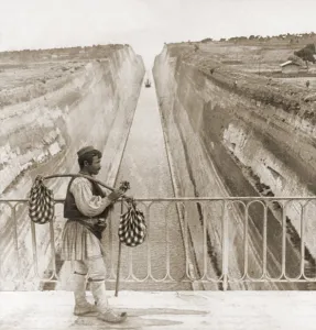 Hydraulic Engineering Prints: Greek man in traditional costume on a bridge over the Corinth Canal built between 1881 and 1893