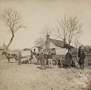 Sign Prints: A group of men stand next to wagons labeled Sam A