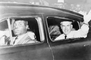 Democratic Prints: Henry A. Wallace waving from an automobile driven by an African American after canceling a speaking engagement