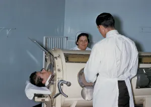 Disabled Prints: Hospital staff are examining a patient in a tank respirator