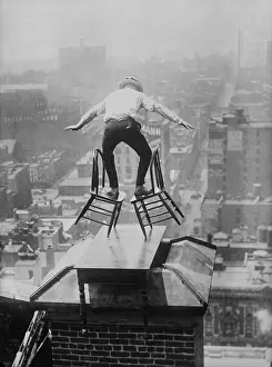 Performer Prints: Human Fly John Jammie Reynolds balances precariously on two tilted chairs