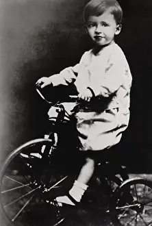 Childhood Prints: Humphrey Bogart belies his tough guy screen persona in a childhood photo on a tricycle