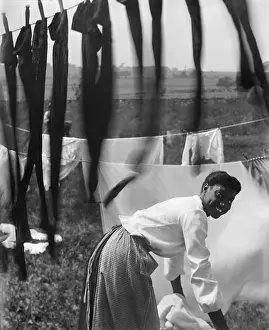Labor Prints: Informal portrait of a young African American woman surrounded by laundry in Newport, R.I