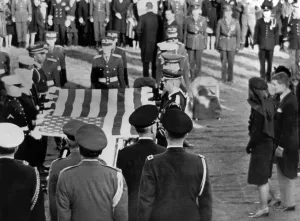 Arlington Prints: Jacqueline Kennedy stands forward as the flag from her husband's coffin is raised for folding