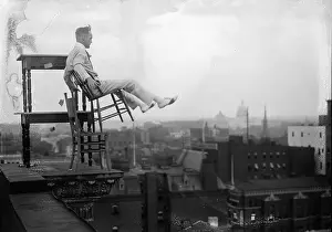 Balancing Act Prints: Jammie Reynolds, balancing on the on chairs on the edge of a rooftop in Washington