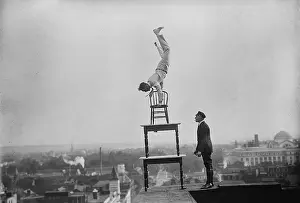 Balancing Act Prints: Jammie Reynolds, balancing on the on chairs on the edge of a rooftop in Washington
