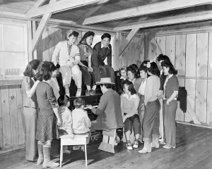 Recreation Prints: Japanese-American internees gathered around piano at Manzanar War Relocation Center