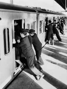 Public Prints: Japanese college students employed as uniformed pushers cramming Tokyo commuters into railroad passenger cars