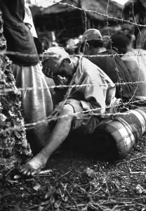 Captured Prints: Japanese soldier sits dejectedly in a prisoner of war enclosure on Okinawa