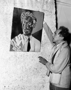 Artist Prints: Jean Cocteau adjusts his self-portrait at an exhibition in Nice