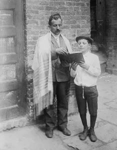Holidays Prints: Jewish man wearing a prayer shawl and boy reading from Hebrew Bible on Yom Kippur