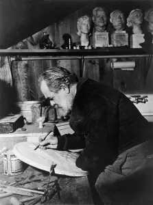Davidson Prints: Jo Davidson (1883-1952), Russian American sculptor at work on a marble plaque in his studio