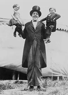Giant Prints: Johan John Aasen holding a midget, in each hand, ca. 1923