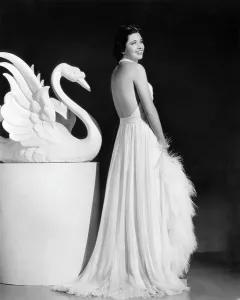 1930s Fashion Prints: Kay Francis modeling white chiffon evening gown, 1937