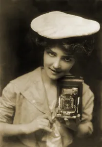 Advertisement Prints: THE KODAK GIRL, a pretty girl posed with camera in a 1909 Kodak advertisement
