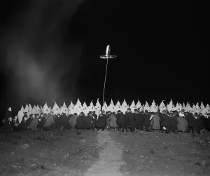 Nighttime Prints: Ku Klux Klan gathering with fully robed and hooded members and kneeling men in face masks
