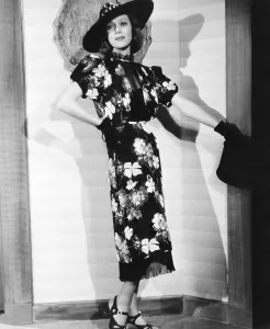 Print Dress Prints: LADIES IN LOVE, Loretta Young in floral print dress with tie-on apron skirt designed by Gwen Wakeling