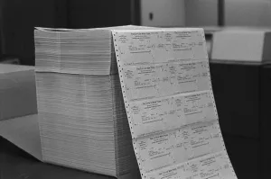August Prints: Large stack of computer generated welfare checks at a New York City welfare office