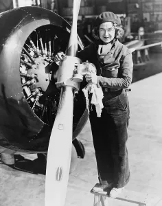 Record Holder Prints: Laura Ingalls (1901-1967), American female aviator atop ladder maintaining an airplane propeller