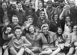 Liberation Prints: Liberated women prisoners at Dachau Concentration Camp wave and cheer for a group portrait