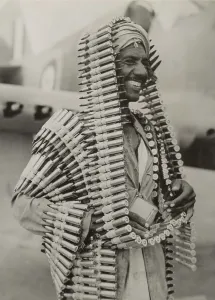Libya Prints: Libyan Arab assistant in the Royal Air Force carries ammunition for a Kittyhawk fighter