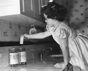 Metals Prints: A little girl deposits a tooth paste tube in a household collection jar during World War 2