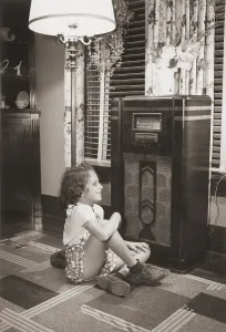 Curtains Prints: Little girl smiles as she enjoys a radio program in the 1930s