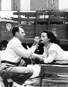 Hollywood Prints: Makeup artist Ben Nye applying eye makeup to actress Hedy Lamarr who observes in a mirror