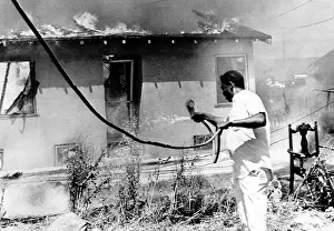 Images Dated 3rd March 2007: A man attempts to stop the fire destroying his home during the Watts riots