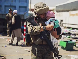 Baby Prints: A US Marine holds a baby while its family is cleared for during the non-combatant evacuation operation at Kabul