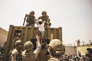 Disorder Prints: US Marines lift a child over a barrier at Kabul Airport, Afghanistan, Aug. 20, 2021