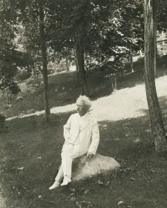 Novelist Prints: Mark Twain (aka Samuel Clemens), seated on a rock in a park. 1905-1910 (BSLOC_2016_11_136)