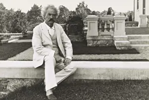 Novelist Prints: Mark Twain sitting on terrace in his preferred dress, a white linen suit, ca. 1900-1910