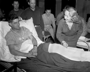 Movie Stars Prints: Marlene Dietrich, autographs the cast on the leg of Tec 4 Earl McFarland of Cavider