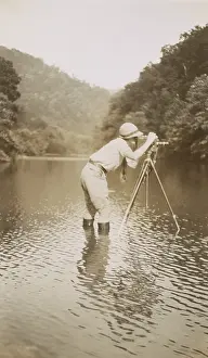Marvin Prints: Marvin Breckinridge Patterson taking a photograph while standing in a river, 1935