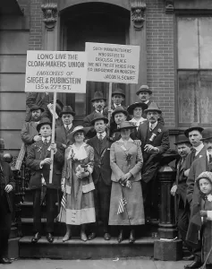Garments Prints: On May Day, striking cloak makers display a sign reading