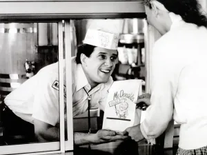 Customers Prints: McDonald's restaurant crew member at the window handing a customer a bag