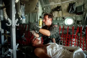 Warrior Prints: A medic adjusts the intravenous drip bag of a wounded US serviceman en route to a medical facility after the invasion
