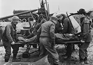 Teamwork Prints: Medics carry a wounded U.S. soldier away from a rescue helicopter