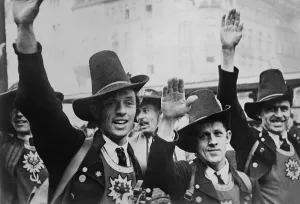 Austria Prints: Men in Tyrolean costume celebrate the German annexation of Austria with a Nazi salute