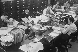 Secretary Prints: Six men and two women at work in a U