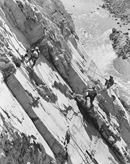 Explosives Prints: Eight men working high up on rock face of canyon wall