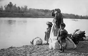 Luggage Prints: Mexican women with her children and bundles on the edge of the Rio Grande River. Ca. 1910