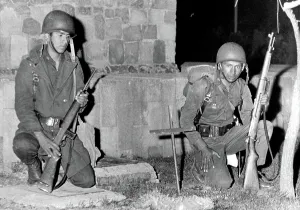 Squatting Prints: Mexico City: Mexican soldiers kneel by cross-marked site where an army trooper was killed by a sniper bullet during
